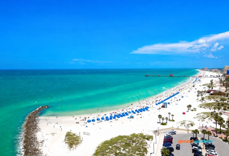 Blick auf einen weißen Sandstrand in Florida mit türkisfarbenem Meer und Pier