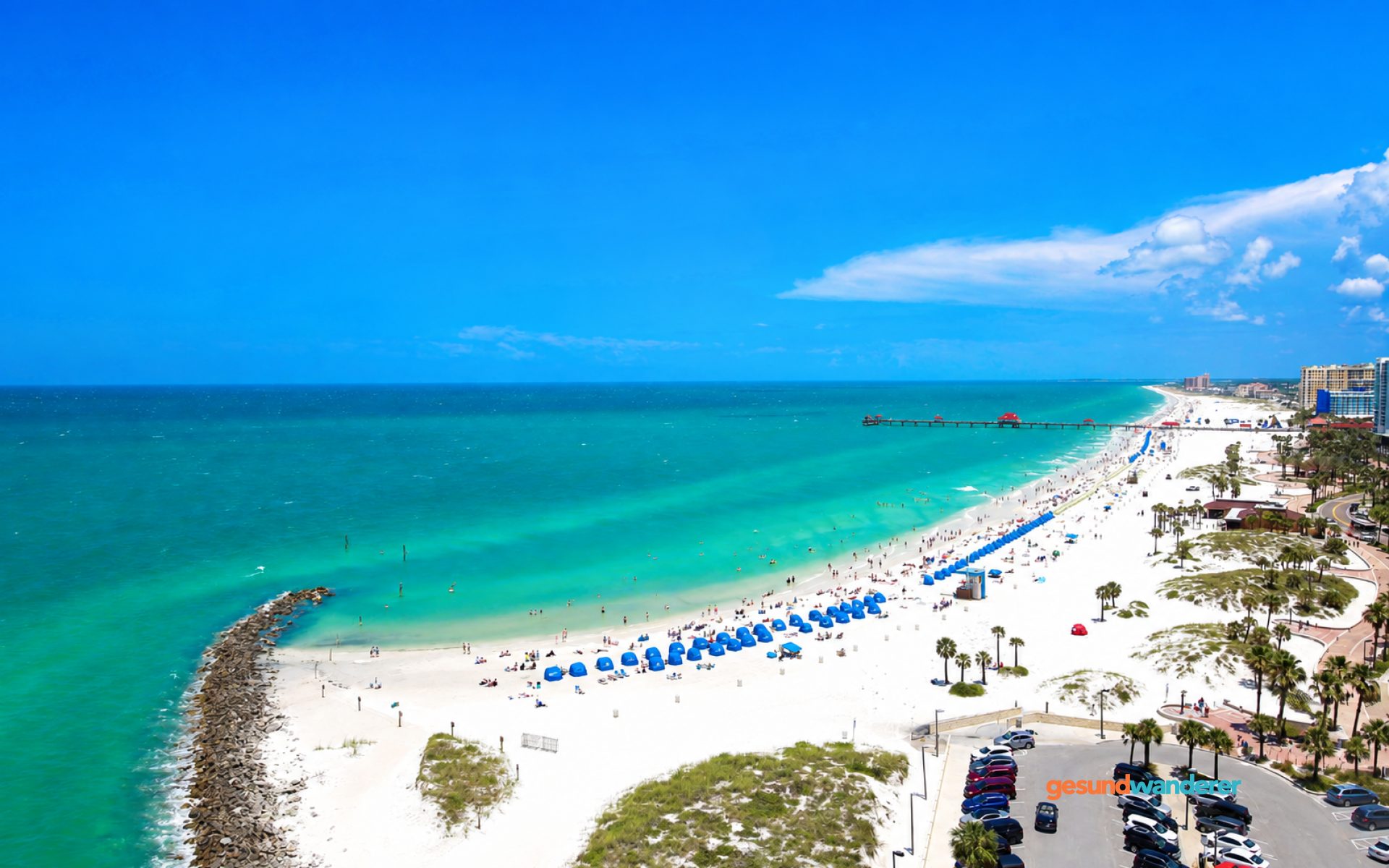 Blick auf einen weißen Sandstrand in Florida mit türkisfarbenem Meer und Pier