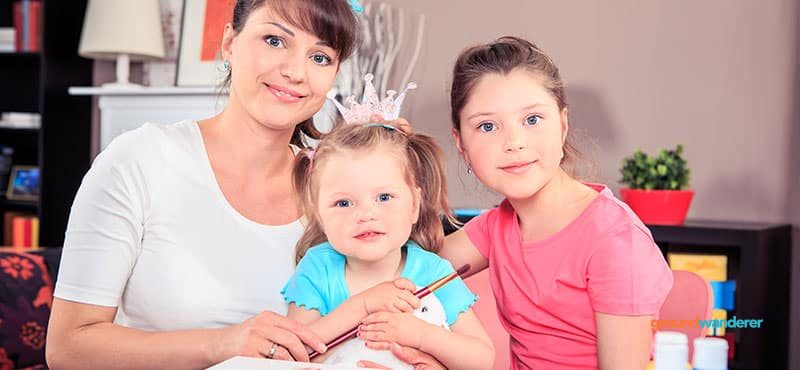 Mutter begleitet zwei Kinder am Tisch